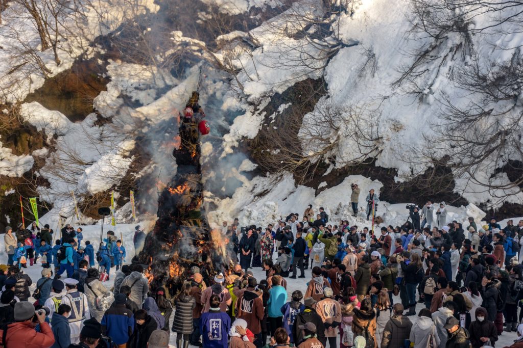 Festival goers wait for the ash to mix with the snow before painting each other's faces with the black ink-like mixture. (Jan 2019)